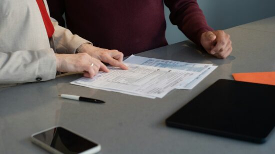 Two professionals reviewing paperwork at a conference table during a business meeting in San Francisco.