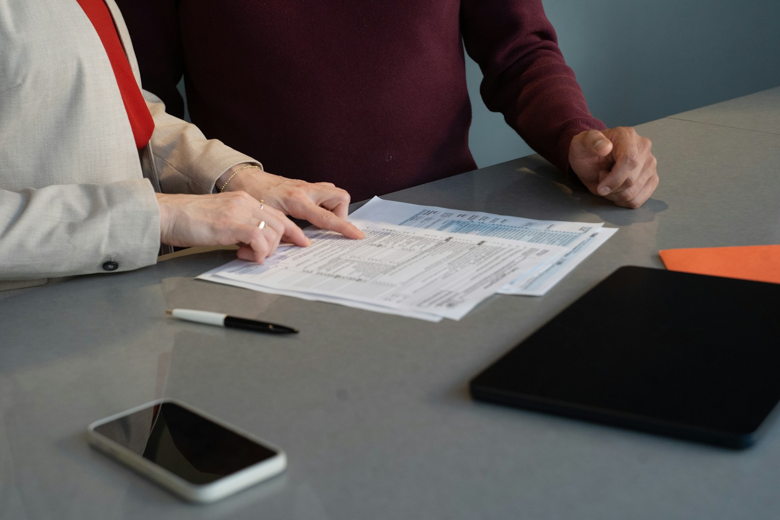 Two professionals reviewing paperwork at a conference table during a business meeting in San Francisco.